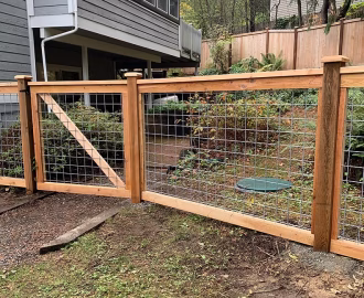 Cedar and wire fence blocking off a garden.