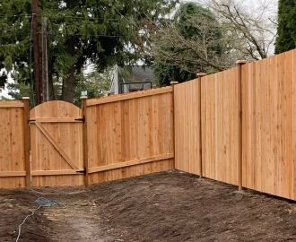Cedar fence with freshly tilled soil.